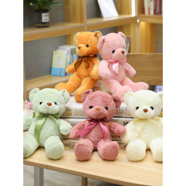 Colorful Bear Doll Plush Toys in various shades including pink, blue, purple, and green displayed on shelves and a chair, perfect for gifting or cuddling.