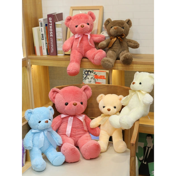 Colorful Bear Doll Plush Toys in various shades including pink, blue, purple, and green displayed on shelves and a chair, perfect for gifting or cuddling.